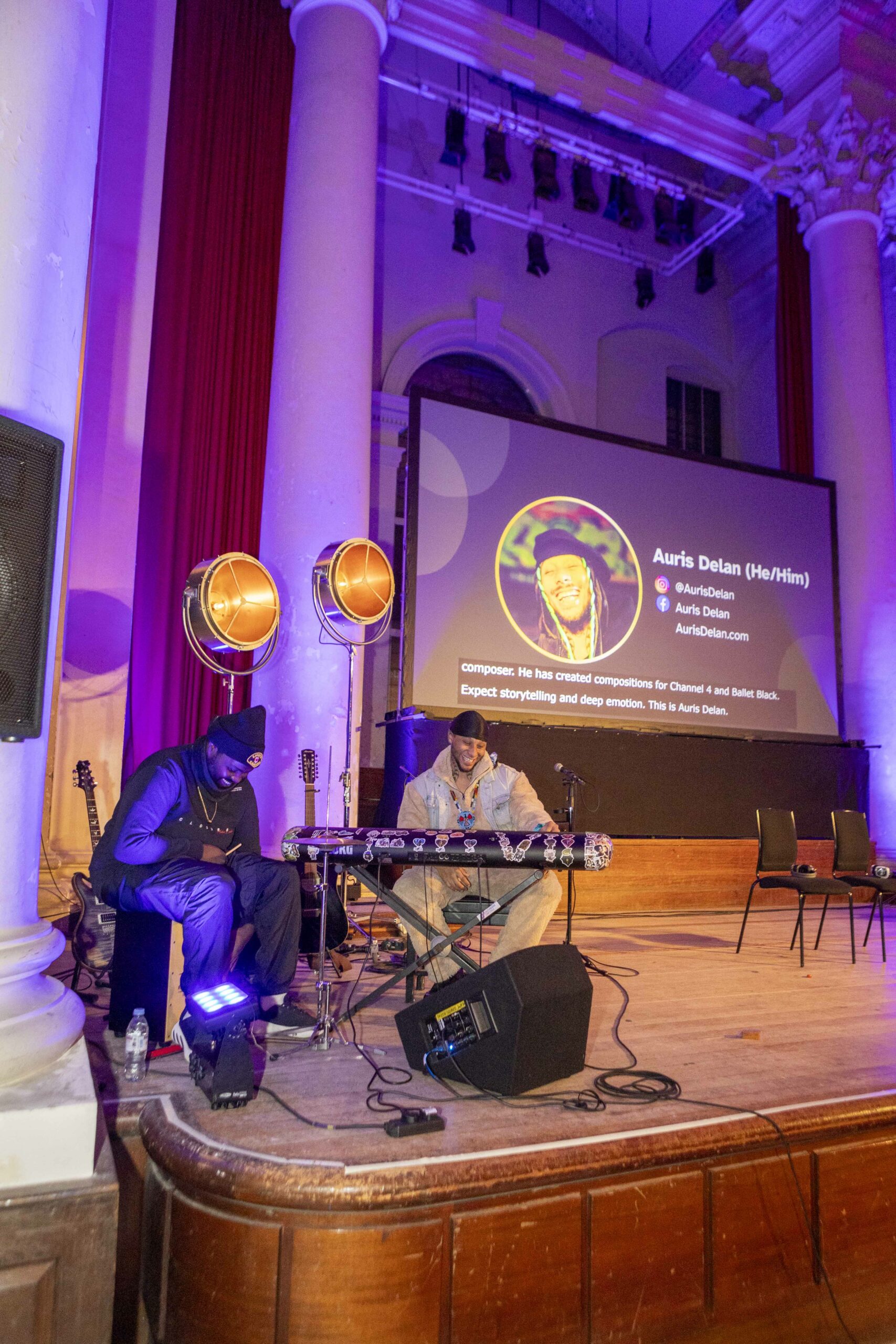 Next Stage artist Auris Delan sitting at keyboard performing at Attitude is Everything's Charter Relaunch event at Sinfonia Smith Square, 12th Feb 2025. He sits with his guitarrist.